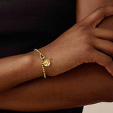 Pulseira Moeda Globo - Ouro 18K em uso | SILLENE