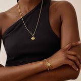 Pulseira Moeda Globo - Ouro 18K em uso | SILLENE