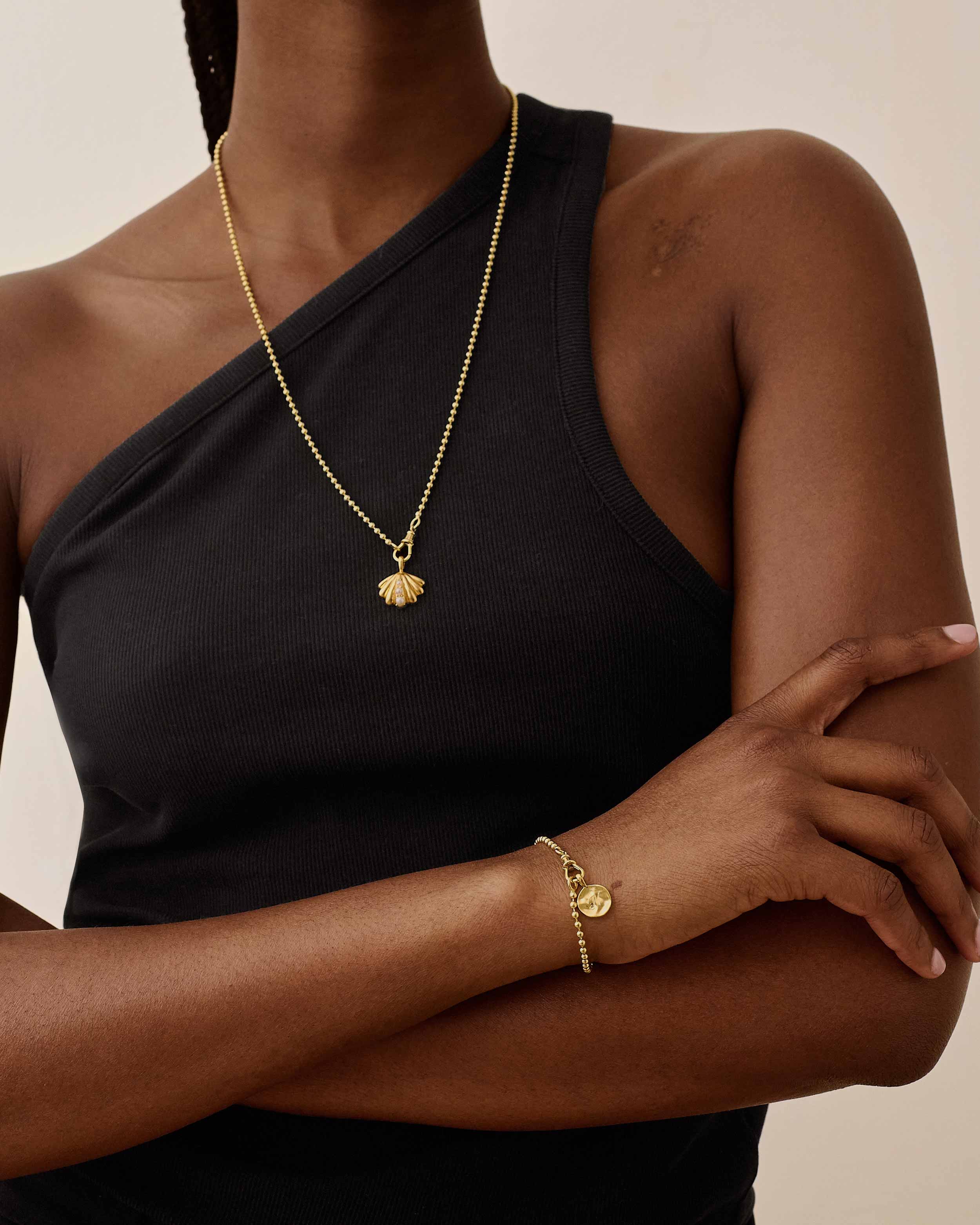 Pulseira Moeda Globo - Ouro 18K em uso | SILLENE