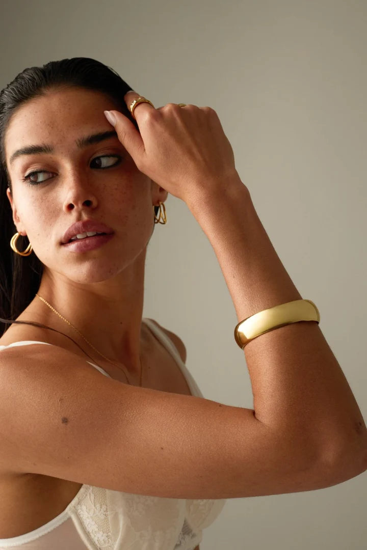 Modelo usando braceletes dourados SILLENE